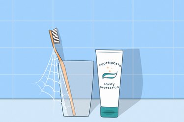 illustration of a bathroom counter with a toothbrush in a cup with cobwebs next to a tube of toothpaste